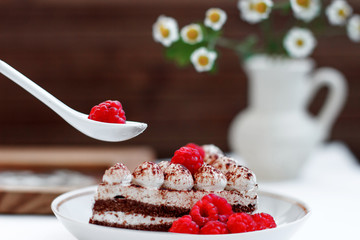cake with raspberries on a background of daisies