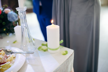 Fototapeta na wymiar Big white candle on the wedding table