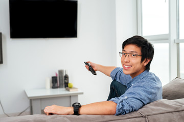 Young asian man in shirt watching tv