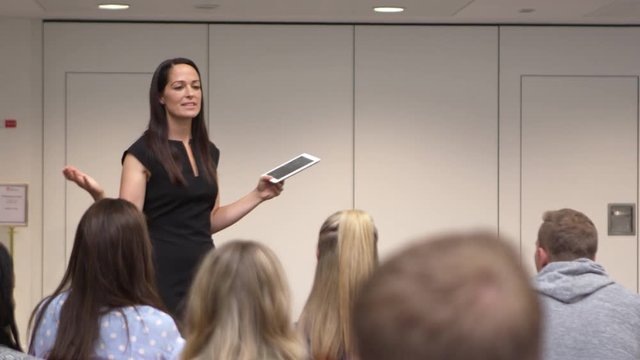 Female teacher addressing university students in class, shot on R3D