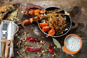 Buckwheat with sauce and chicken kebabs on skewers on a plate