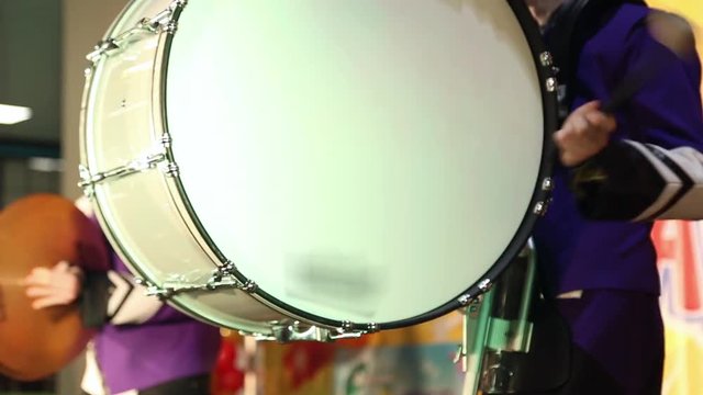 The drummer plays on big drum on stage
