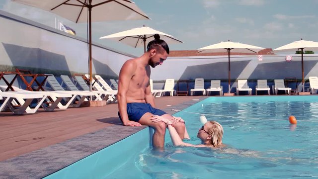 couple in love kissing, girl and guy kiss, swimming in the pool, relax in the hot spa, swimming, to swim, used the pool on the hotel's territory, she emerges from the water, happy family vacation