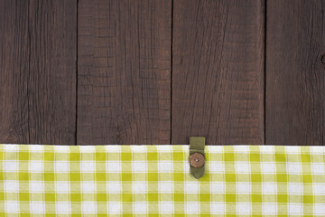 Green checkered tablecloth on wooden table.