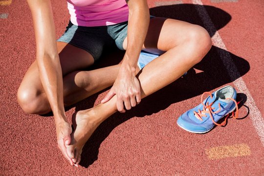 Female Athlete With Foot Pain On Running Track