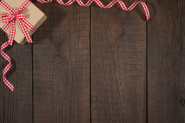 Gift box on an old dark wooden table.