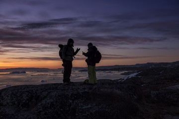people silhouette with sunset in Greenland