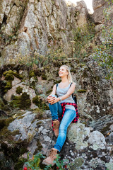 Full length traveling girl sitting on rock