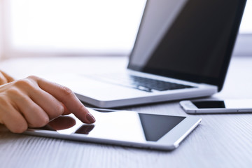 Woman's hands using tablet pc and laptop at the office