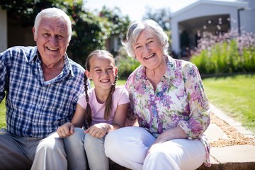 Grandparents and granddaughter sitting in the garden