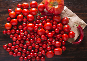 Tomatoes of different varieties. Colorful tomatoes Tomatoes background. Fresh tomatoes Healthy food concept. Colorful festive still life. Loosely laid tomatoes in different positions.