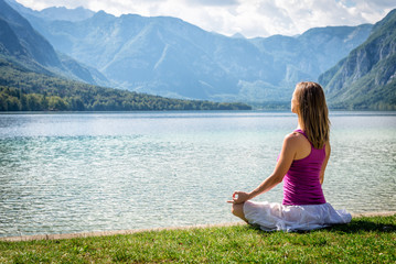 Naklejka na ściany i meble Woman meditating at the lake