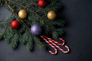 Christmas decorations with fir-tree branches, New Year's spheres, tangerines and candies
