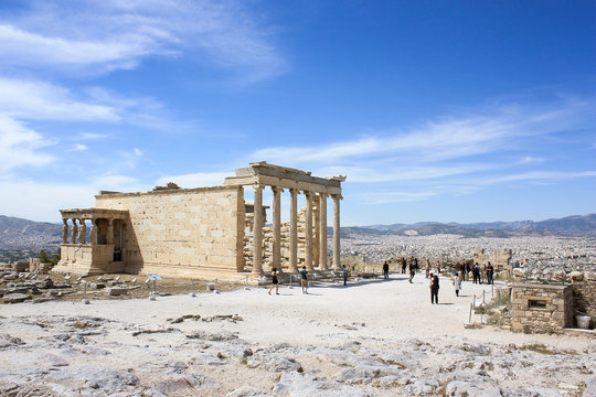 Acropolis with blue sky on the background and unknown tourists.