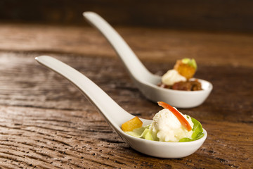 Baby lettuce salad, cherry tomatoes, palm hearts, cauliflower sauce, fried manioc and salted whipped cream in a spoon. Taste gastronomy fingerfood