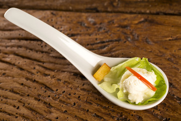 Baby lettuce salad, cherry tomatoes, palm hearts, cauliflower sauce, fried manioc and salted whipped cream in a spoon. Taste gastronomy fingerfood