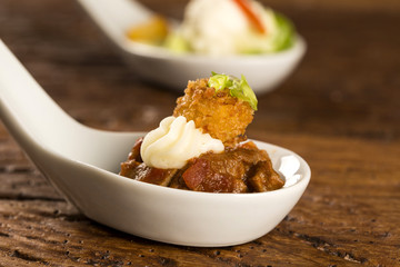 Filet mignon with spices, lemon zest, creamy curd and fried banana in a spoon. Taste gastronomy fingerfood