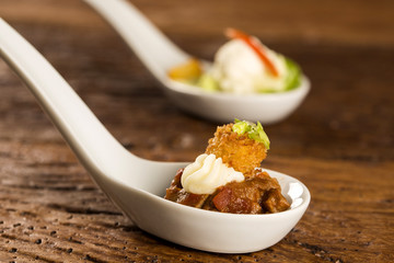 Filet mignon with spices, lemon zest, creamy curd and fried banana in a spoon. Taste gastronomy fingerfood