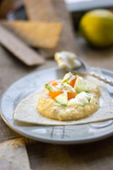 Delicious hummus on blue plate with the fresh vegetables.