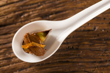 Base of biscuit, mango and passion fruit gel, half bitter chocolate mousse with orange and passion fruit glass in a spoon. Taste gastronomy fingerfood