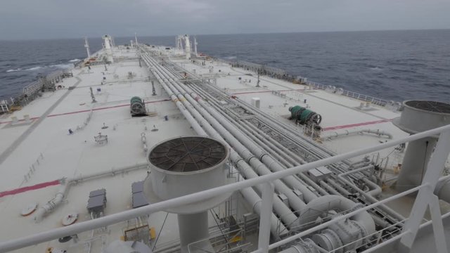 Deck of very large tanker, at sea. Seaman on deck.