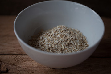 Oat flakes in a bowl on a wooden background selective focus