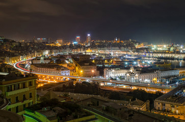 City of Genoa at night with beautifully lit harbor and busy streets full of traffic