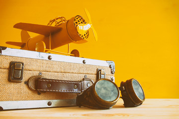 vintage toy plane and old suitcase on wooden table