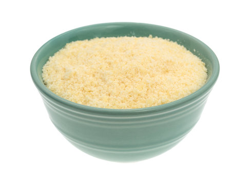 Parmesan cheese in a green bowl side view isolated on a white background.