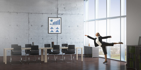 Dancing businesswoman in office room . Mixed media