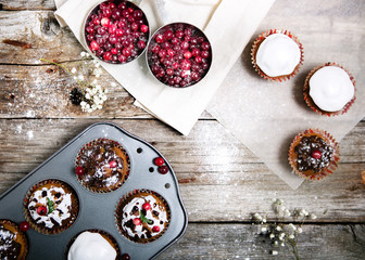 Composition of muffins decorated for the New Year, berries and wooden background