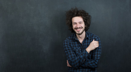 Portrait of a fashionable young man with funny hair on dark back