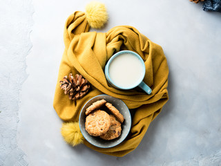 Obraz na płótnie Canvas Mug of tea and cookies in winter scarf. Top view