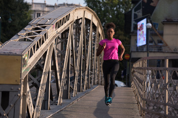 african american woman running across the bridge