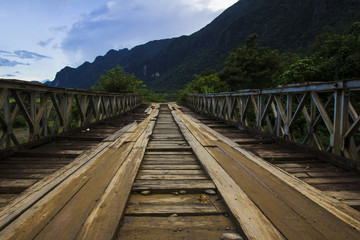 Fototapeta premium worn out wooden bridge in laos countryside