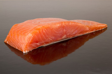 Salmon fillet on black background.