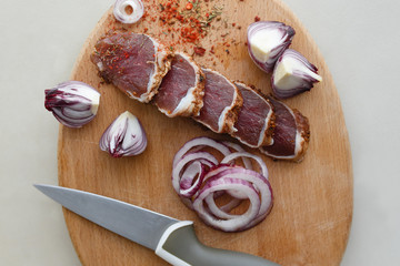 Salted meat with spices on a wooden board
