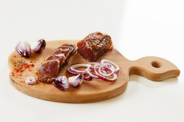 Salted meat with spices on a wooden board
