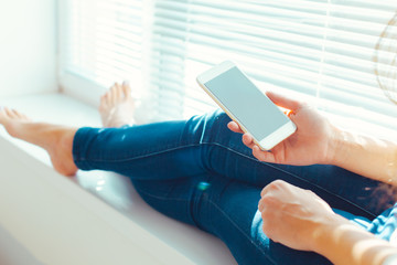 Woman with modern mobile phone in hands