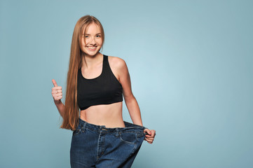 Women shows her weight loss.