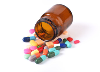 Recipient of medicine and many pills isolated on white backgroun