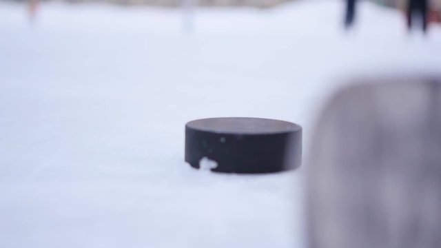 Slow Motion Hockey - player shot a stick on the puck closeup