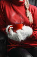 girl in red sweater and white mittens holding cup