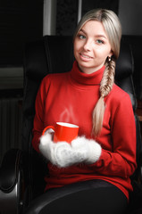 woman in red sweater and white mittens holding cup