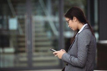 Businesswoman text messaging on mobile phone