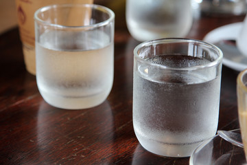 Glass of cold fresh water on wooden table.