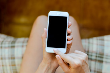 Hands of woman using cellphone with blank screen background