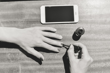 Top view on cell phone and hands doing manicure. Close up table mockup background