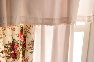 White curtains and window. Cloth with floral pattern. Simplicity of design. Welcome the new day.