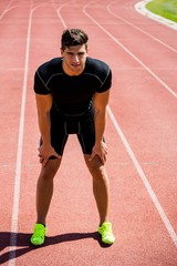 Obraz premium Tired athlete standing on running track